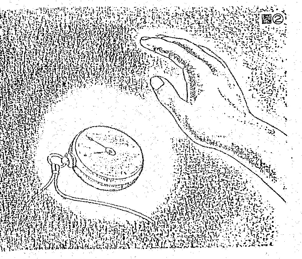 A hand reaching toward a round object, such as a pocket watch, on a textured surface, enclosed in a rectangular frame.